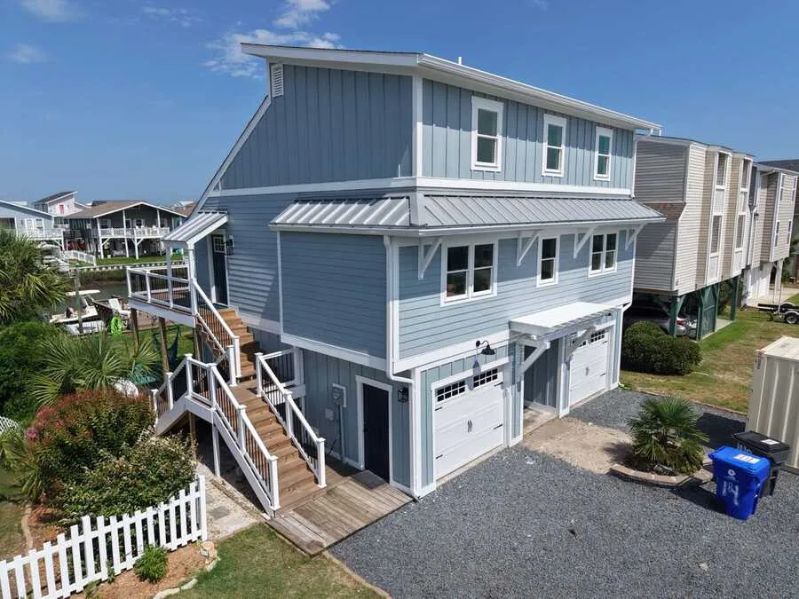 Blue lap-siding home with white trim and metal roof accents