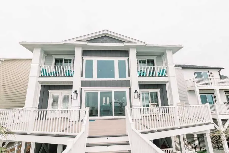 White oceanfront home with tall windows