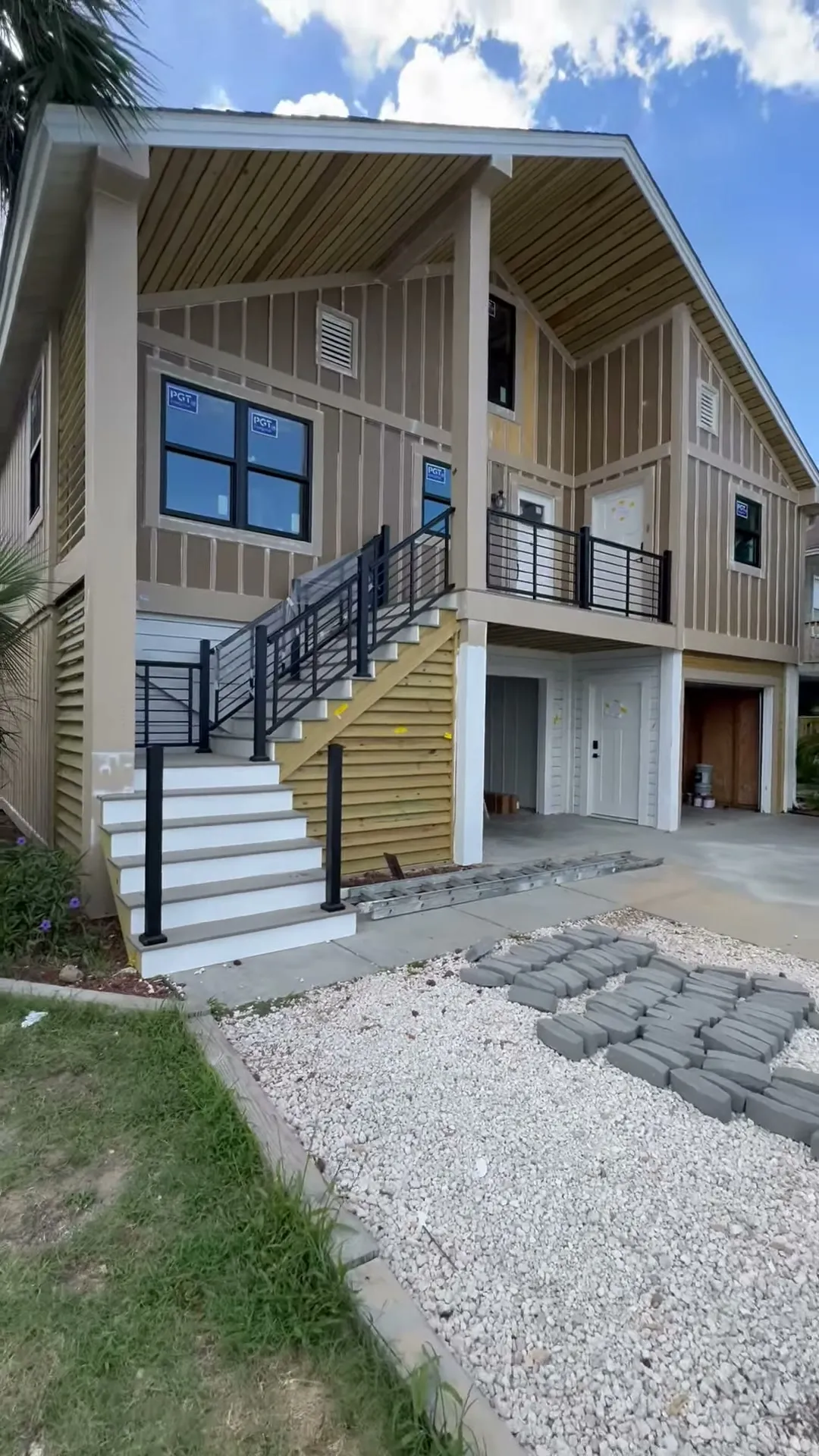 Finished Ocean Isle Beach exterior: board and batten siding, new stairs, aluminum rail and windows