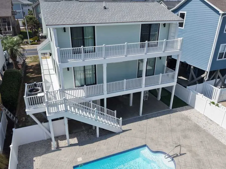 Pool and decks behind a raised beach house